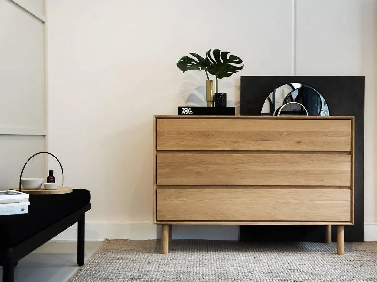 Cómoda de madera clara en un dormitorio