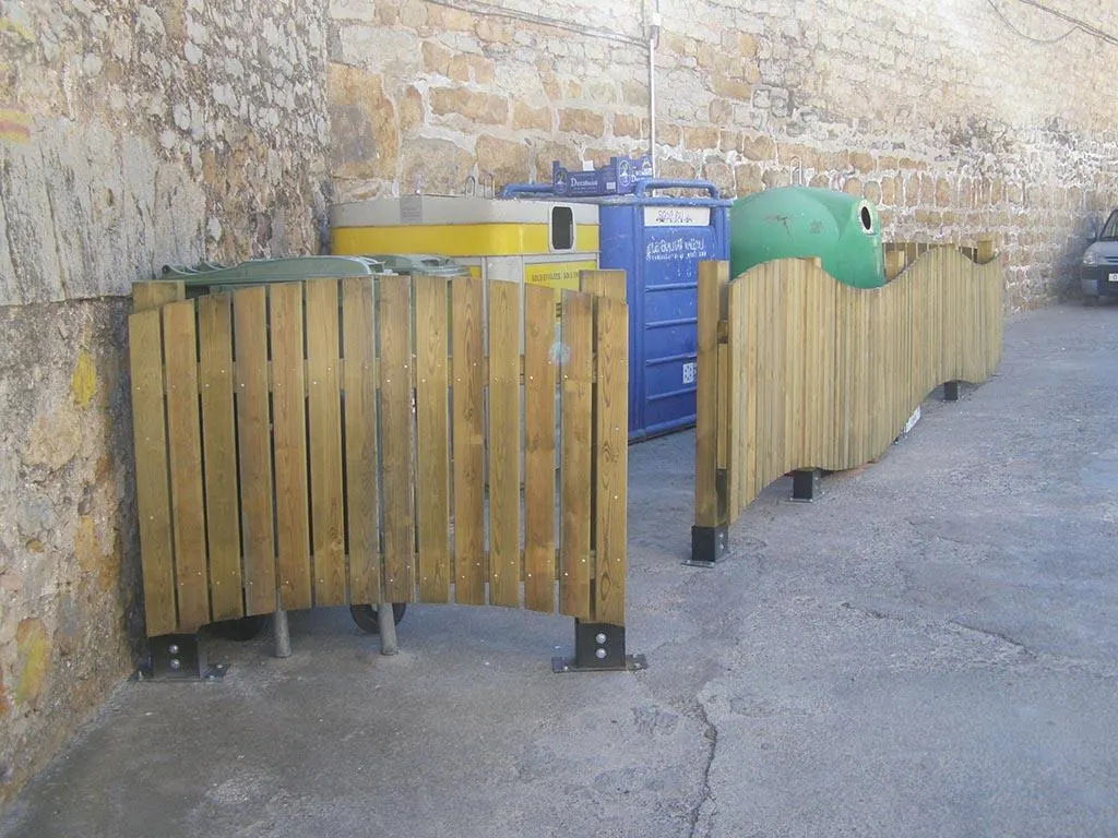 Cubrecontenedor de madera modelo Urbano Curvo instalado delante de contenedores en una calle