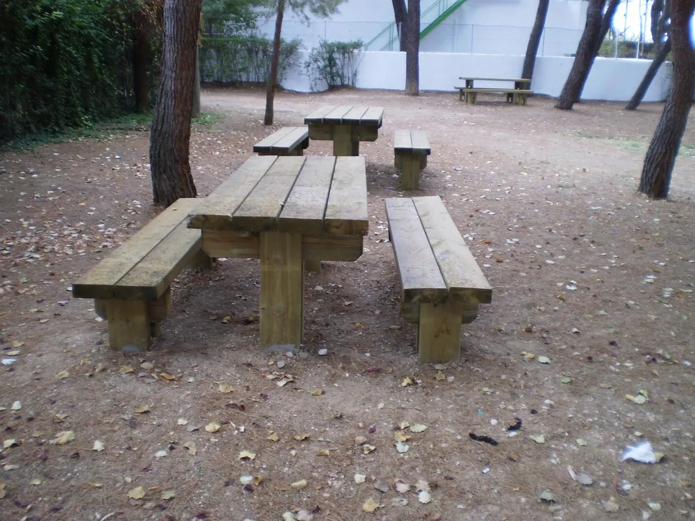 Mesas de madera modelo Natura con bancos independientes en un parque