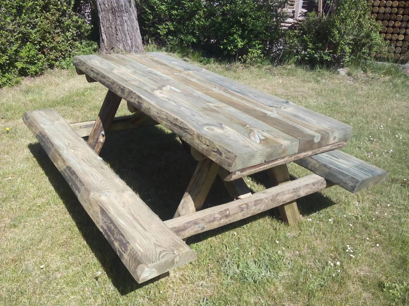 Mesa picnic de madera rústica con bancos incorporados en un parque
