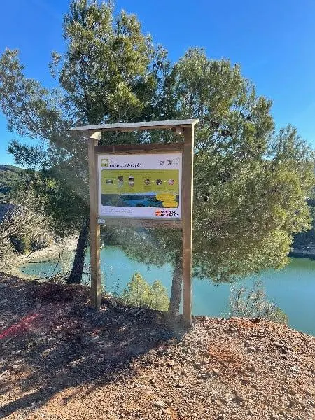 Cartel de madera estándar con tejado a un agua junto a un embalse