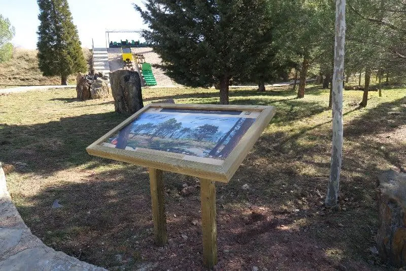 Mesa de interpretación de madera con panel inclinado en un parque