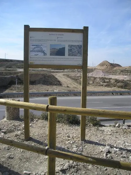 Cartel de madera estándar vertical sin tejado junto a una valla de madera